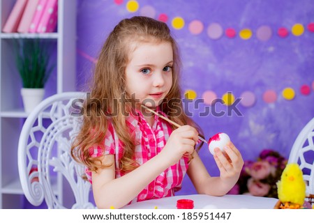 little girl paints eggs for Easter. Easter. holidays, emotions, happy