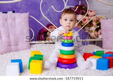 portrait of a beautiful girl. child age 7 months playing with colorful cubes