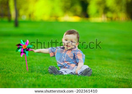 Adorable baby playing in the park. green lawn, smile, emotion, summer
