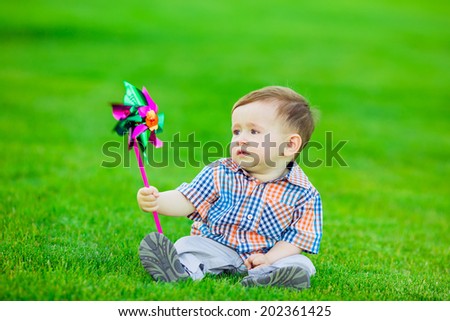 Adorable baby playing in the park. green lawn, smile, emotion, summer