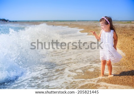 Adorable little girl walking on the beach. happiness, holiday, wind, waves