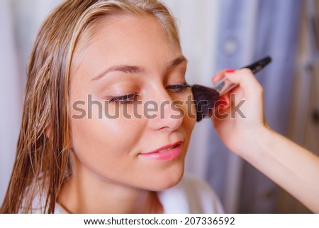 makeup artist doing makeup beautiful girl, close-up
