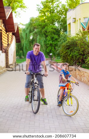 Dad and son at the park and ride on bicycles