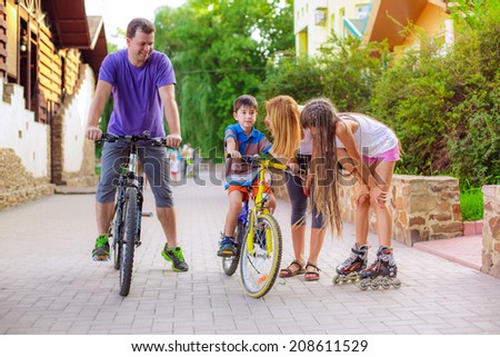 father teaches his son to ride a bike