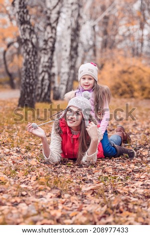 Mom walks in autumn park with her daughter
