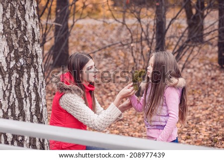 Mom walks in autumn park with her daughter