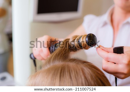 Reflection of hairdresser doing hair style for woman in hairdresser\'s. Concept of fashion and beauty