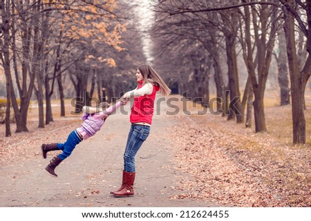 Mum with a daughter walk in autumn park. active rest. Autumn walk, November
