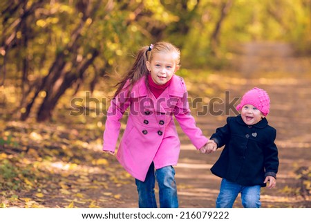 Happy children walk in autumn park