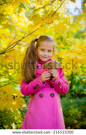 Adorable little girl resting in autumn forest