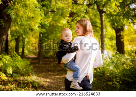 Beautiful mother and daughter on walk in autumn park