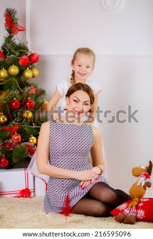 happy mother and daughter in a room near the Christmas tree.  gifts
