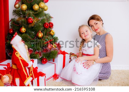 Christmas concept. happy mother and daughter in a room near the Christmas tree.