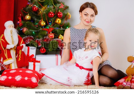 happy mother and daughter in a room near the Christmas tree.