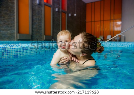 happy mother and son in the pool. playing sports. child development
