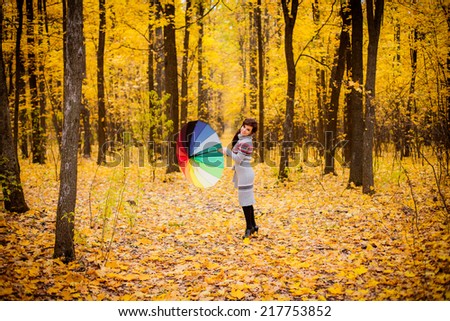 girl with umbrella rainbow colors. autumn forest.
