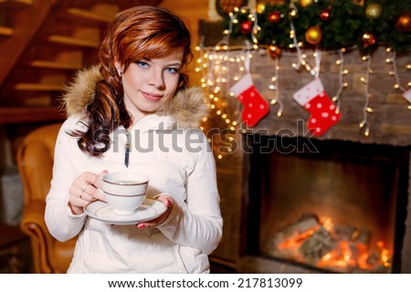 beautiful woman near the fireplace in the winter house. winter. christmas