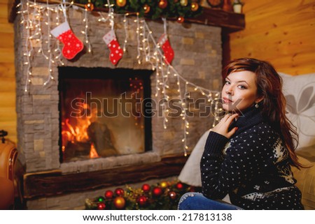 beautiful woman near the fireplace in the winter house. winter. christmas, family holidays