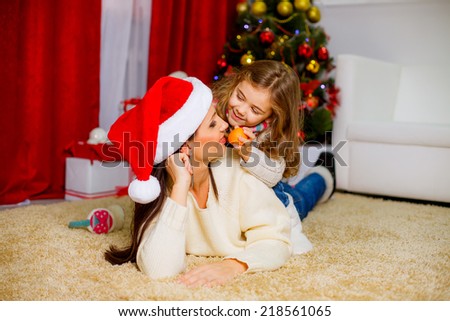 happy mother and daughter in a room near the Christmas tree