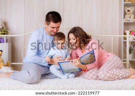 happy parents read a book your child in the nursery.