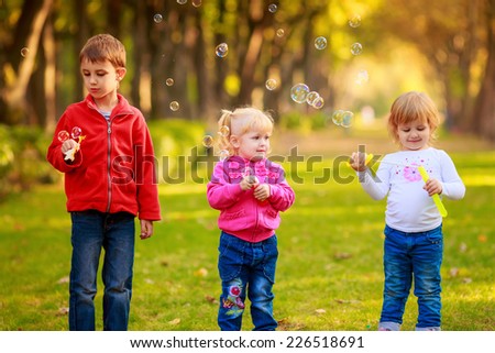 Happy kids with soap bubbles in the park. play, run, active, relaxing, fun, children\'s emotions