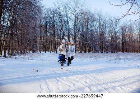 Happy kids throwing snow in the winter forest. Christmas