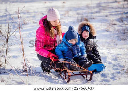 Happy children sledding in the winter forest. Christmas
