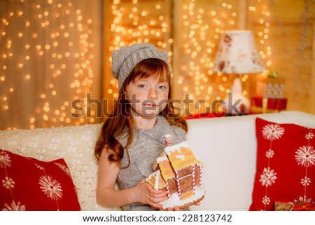happy little girl at home holding a gingerbread house. christmas,illuminations