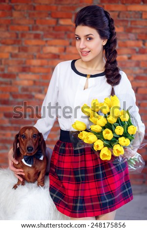 Beautiful girl with Dahshund and yellow tulips. International Women\'s Day. March 8 Mother\'s Day