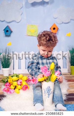 Happy boy with flowers. Yellow and pink tulips, March 8, Mother\'s Day, International Women\'s Day