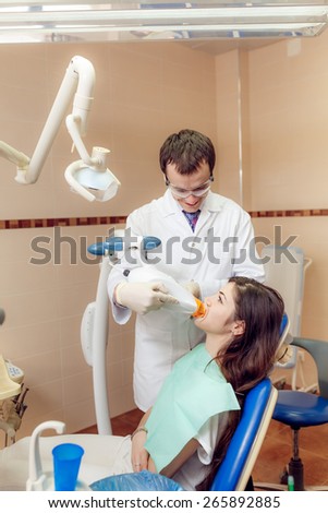 Dentist makes teeth whitening beautiful girl