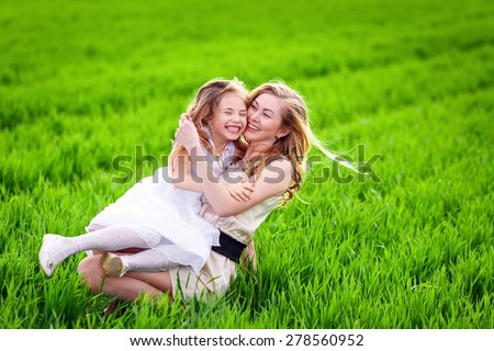 Woman and child playing hide and seek in summer field