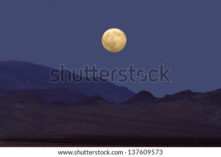 Full moon rising during twilight at the Mojave Desert, California, USA. Moon rising in the California desert.
