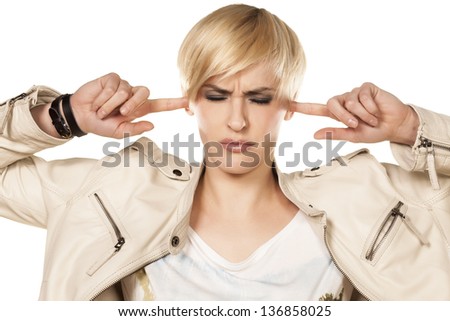 cute short hair blonde girl closes ears on loud sound on the white background