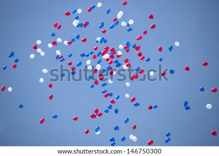 white, red and blue balloons flying all over the sky