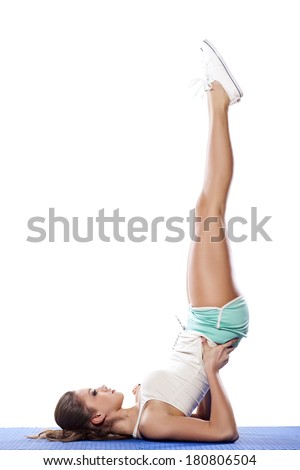Portrait of young girl doing a yoga pose with feet in the air