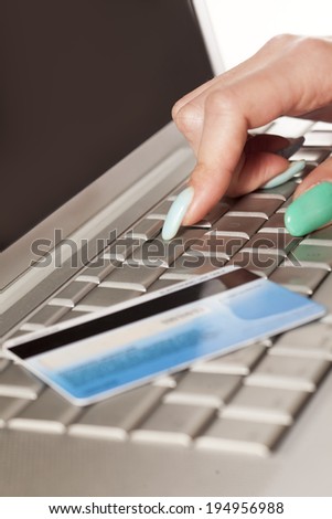 Woman\'s hand entering credit card information into a laptop