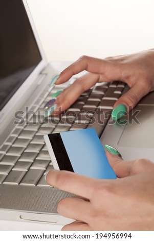 Woman\'s hands entering credit card information into a laptop