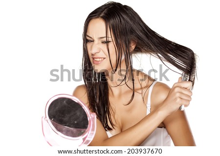 unhappy beautiful young woman comb her wet hair