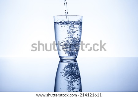 Water flows into the glass and makes bubbles