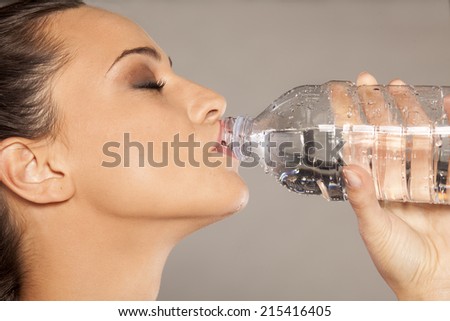 girl drinks water from a plastic bottle