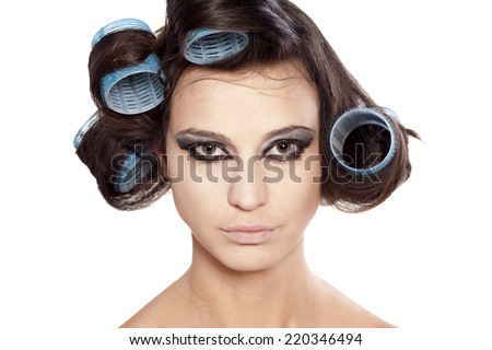 Funny woman with curlers and uncompleted bad makeup