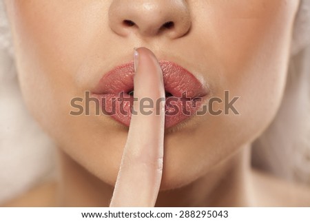 finger on her lips. silence gesture
