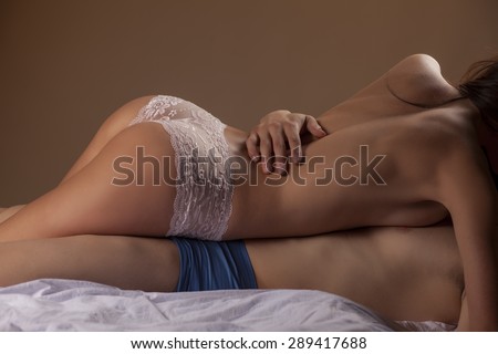 young couple in sensual embrace on white sheets