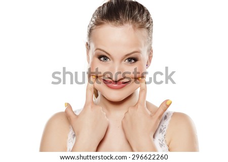 young woman pulls out her mouth with her fingers to smile