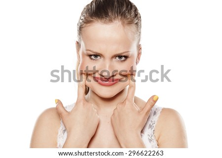 angry woman pulls out her mouth with her fingers to smile
