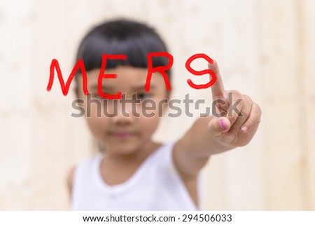 Kid with hand writing to mers word and blur face on wood wall background