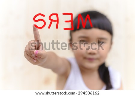 Kid hand writing Mers word  and blur face on wood wall background