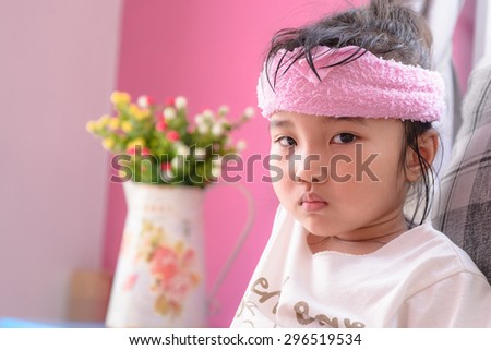 Kid on sick mood with pink towel cold pack
