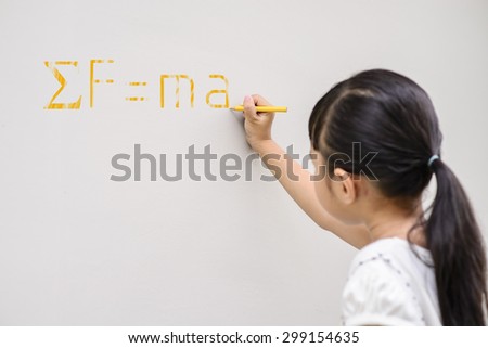 Kid writing yellow scientific formula on the wall